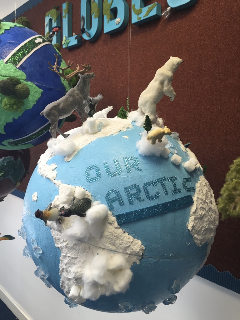 A globe with Arctic animals atop it.