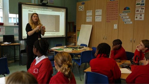 A teacher addresses a class of children